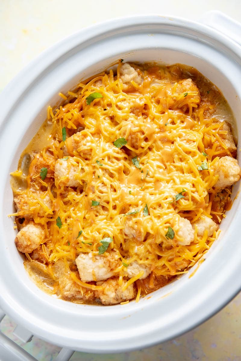 oval casserole slow cooker filled with buffalo chicken tater tot casserole with melted cheese