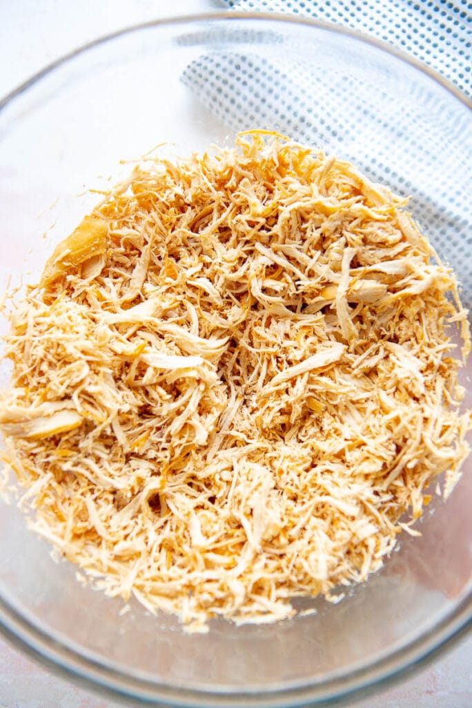 glass bowl filled with shredded chicken