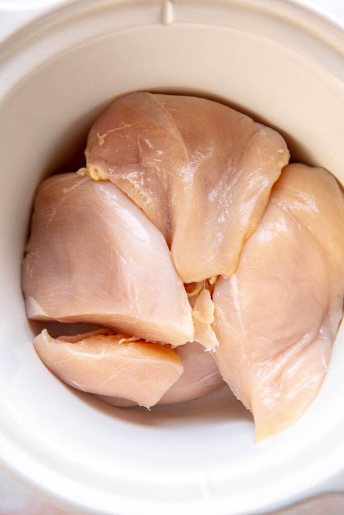 chicken breasts in a round white slow cooker