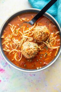 blue bowl filled with spaghetti and meatballs soup