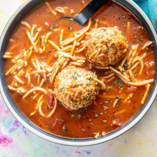 blue bowl filled with spaghetti and meatballs soup