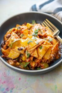 enchilada casserole with melted cheese and cilantro in a blue shallow bowl