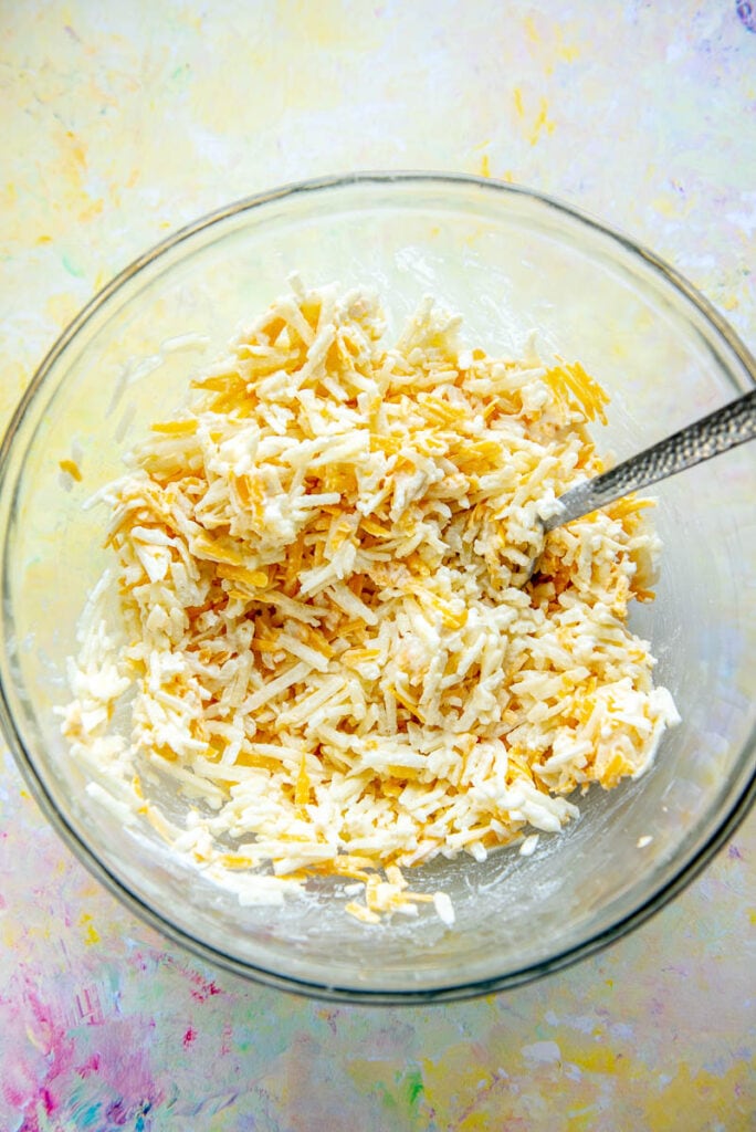 hash brown casserole ingredients mixed in glass bowl