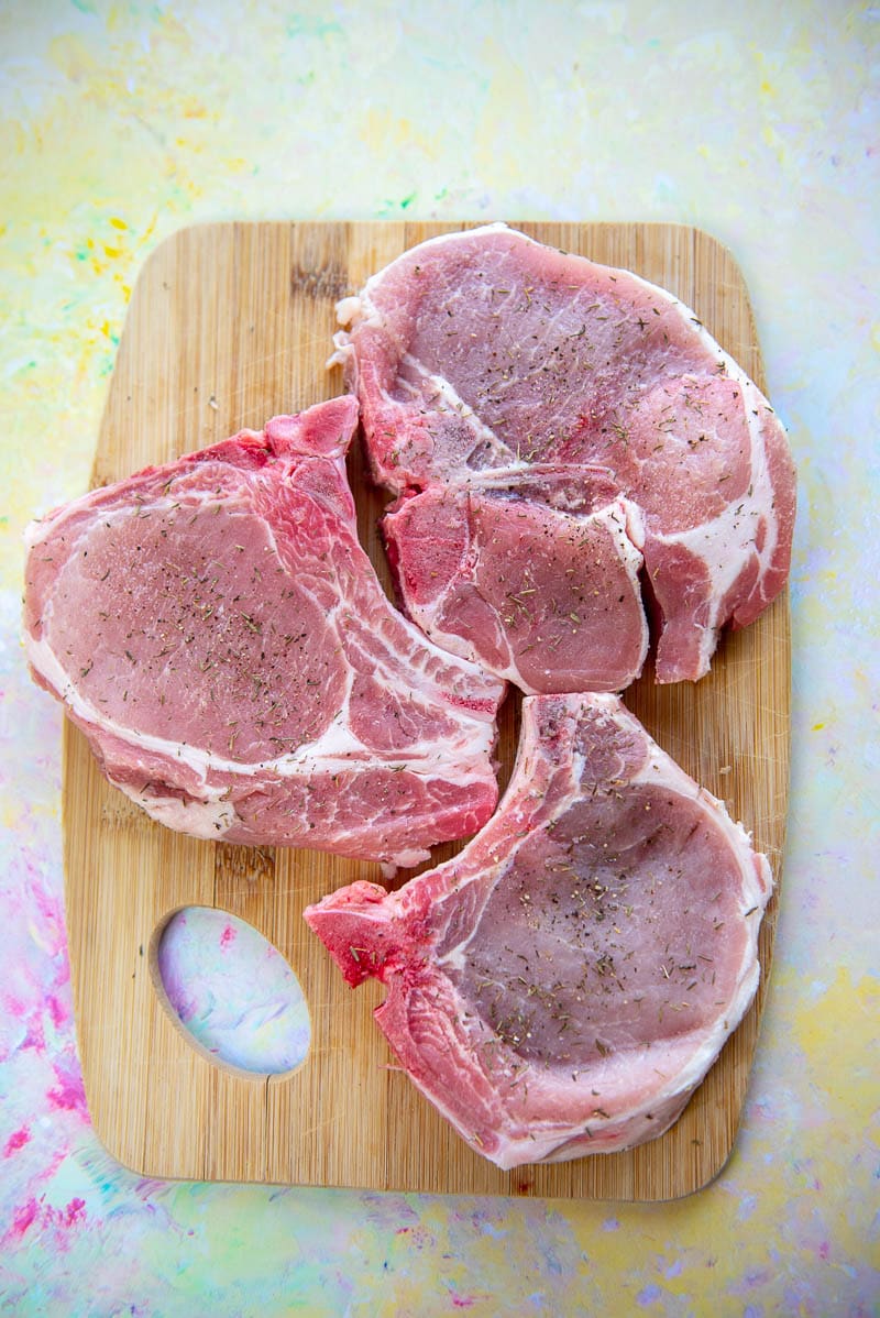 raw pork chops on cutting board