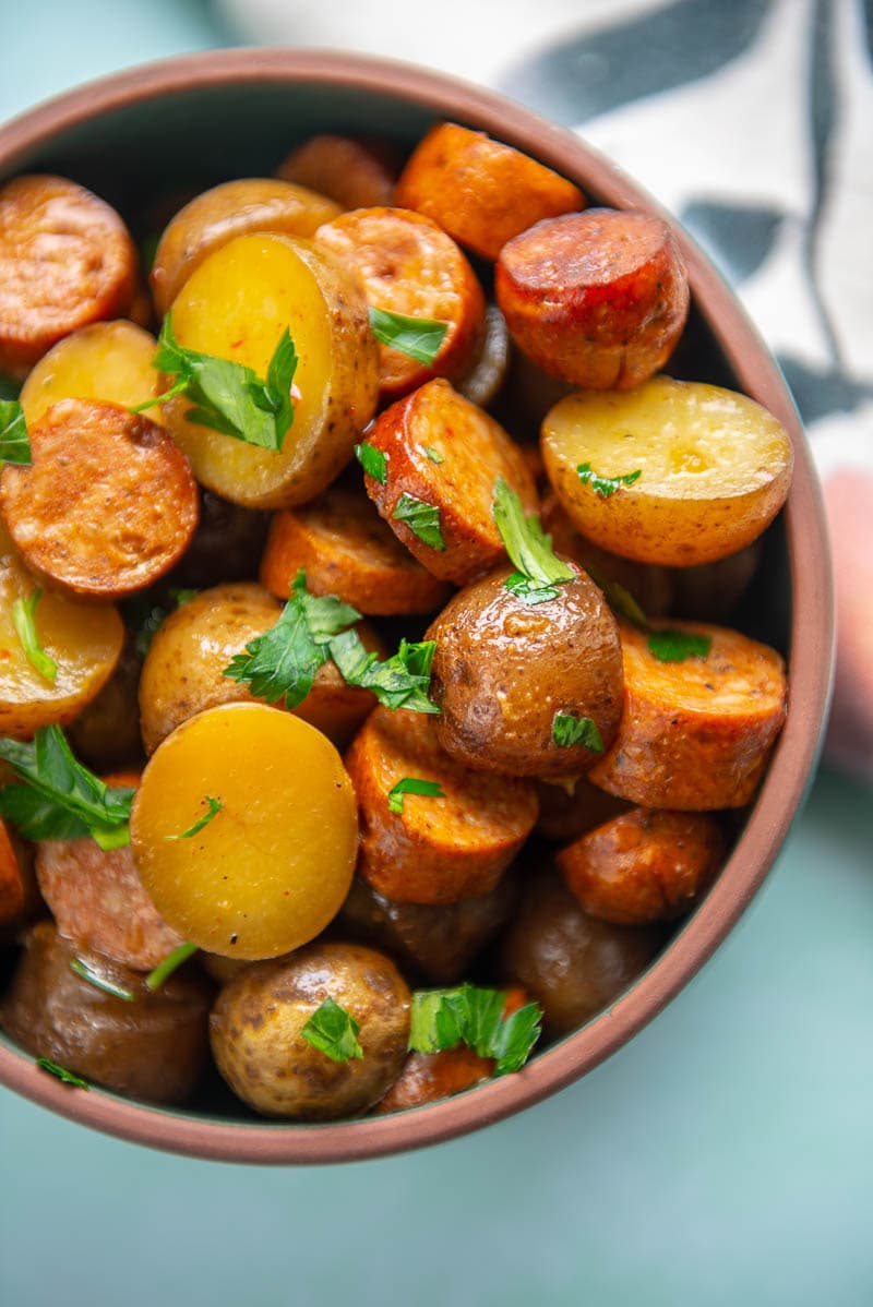 close up of potatoes and sausage topped with parsley