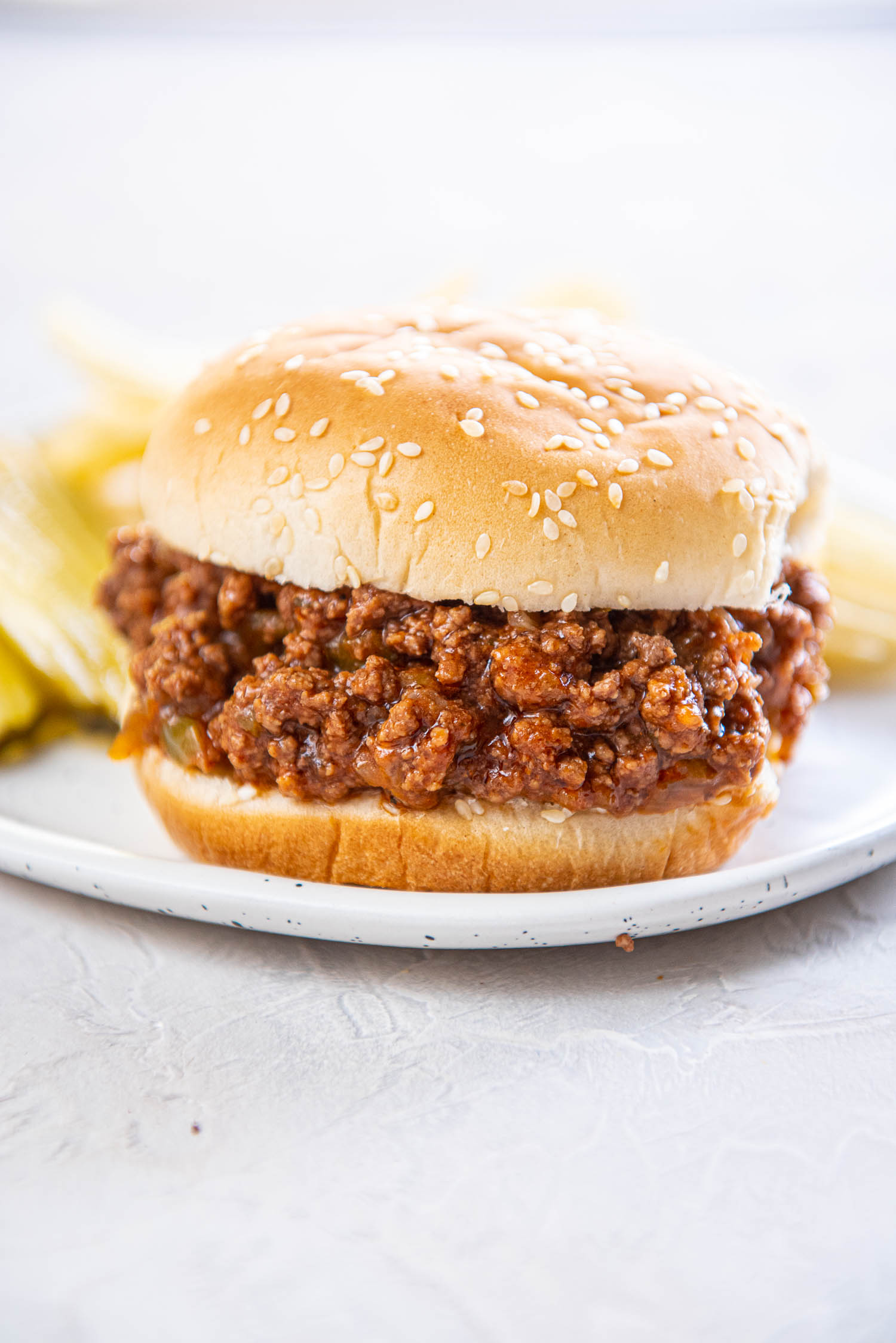 sloppy Joe on sesame bun on white plate