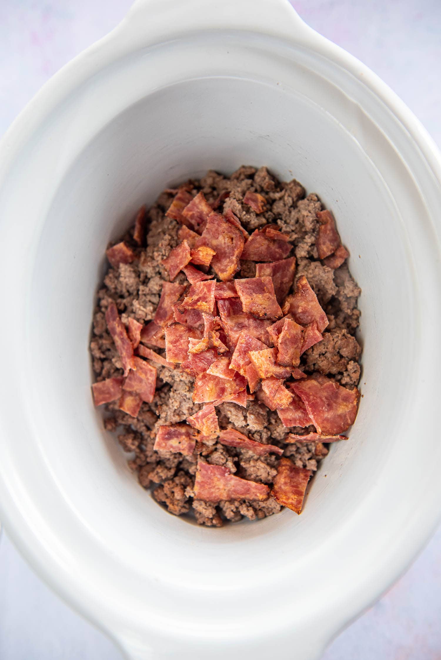 browned ground beef and chopped cooked bacon in slow cooker