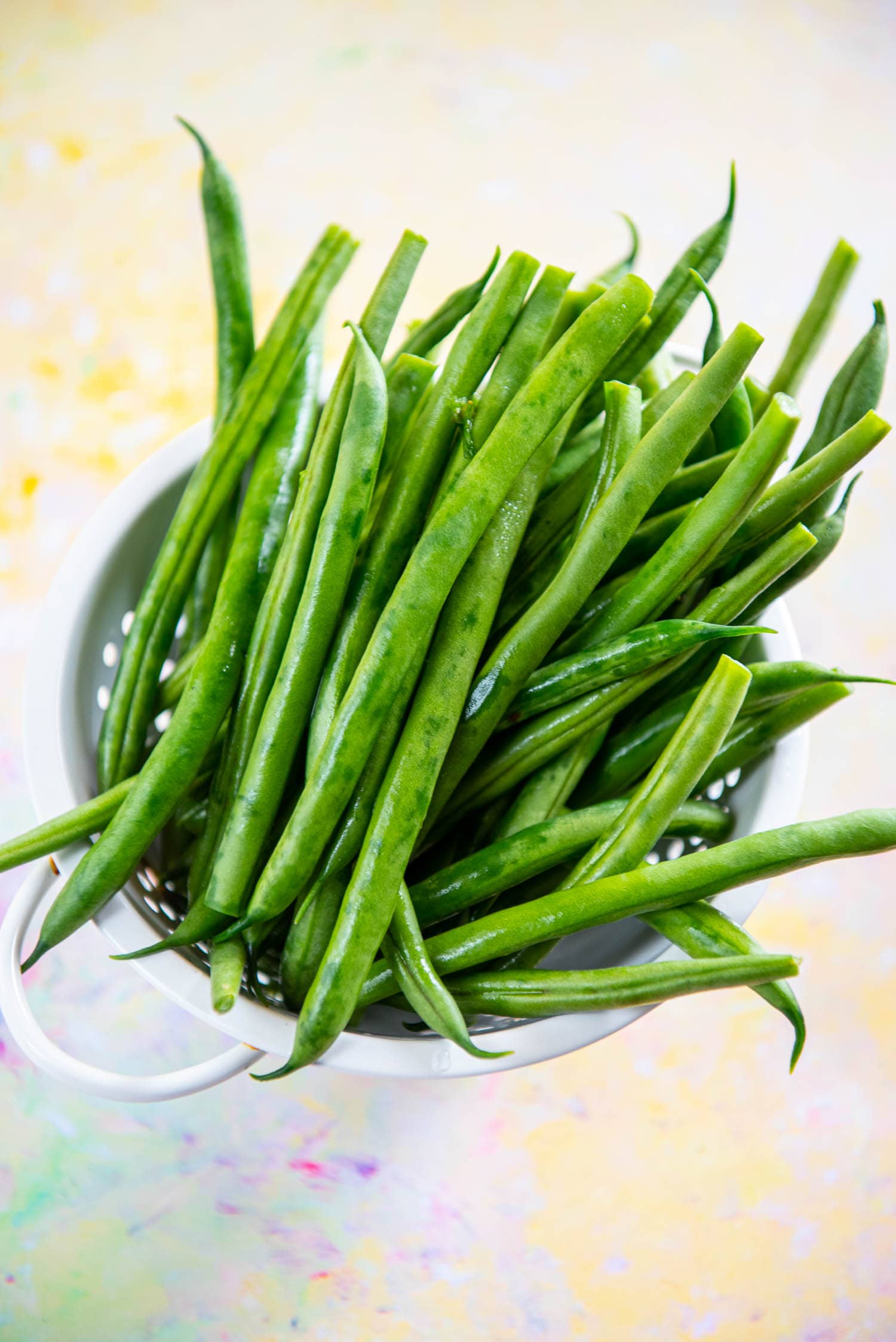 fresh green beans in white colander