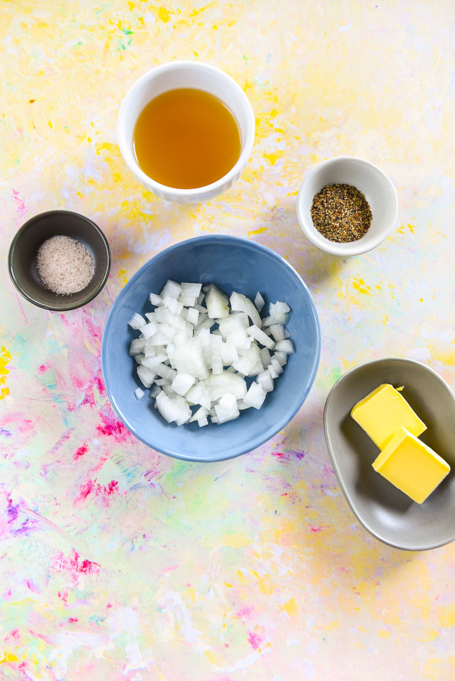 shallow bowls filled with salt, seasoning, chicken broth, butter and chopped onion