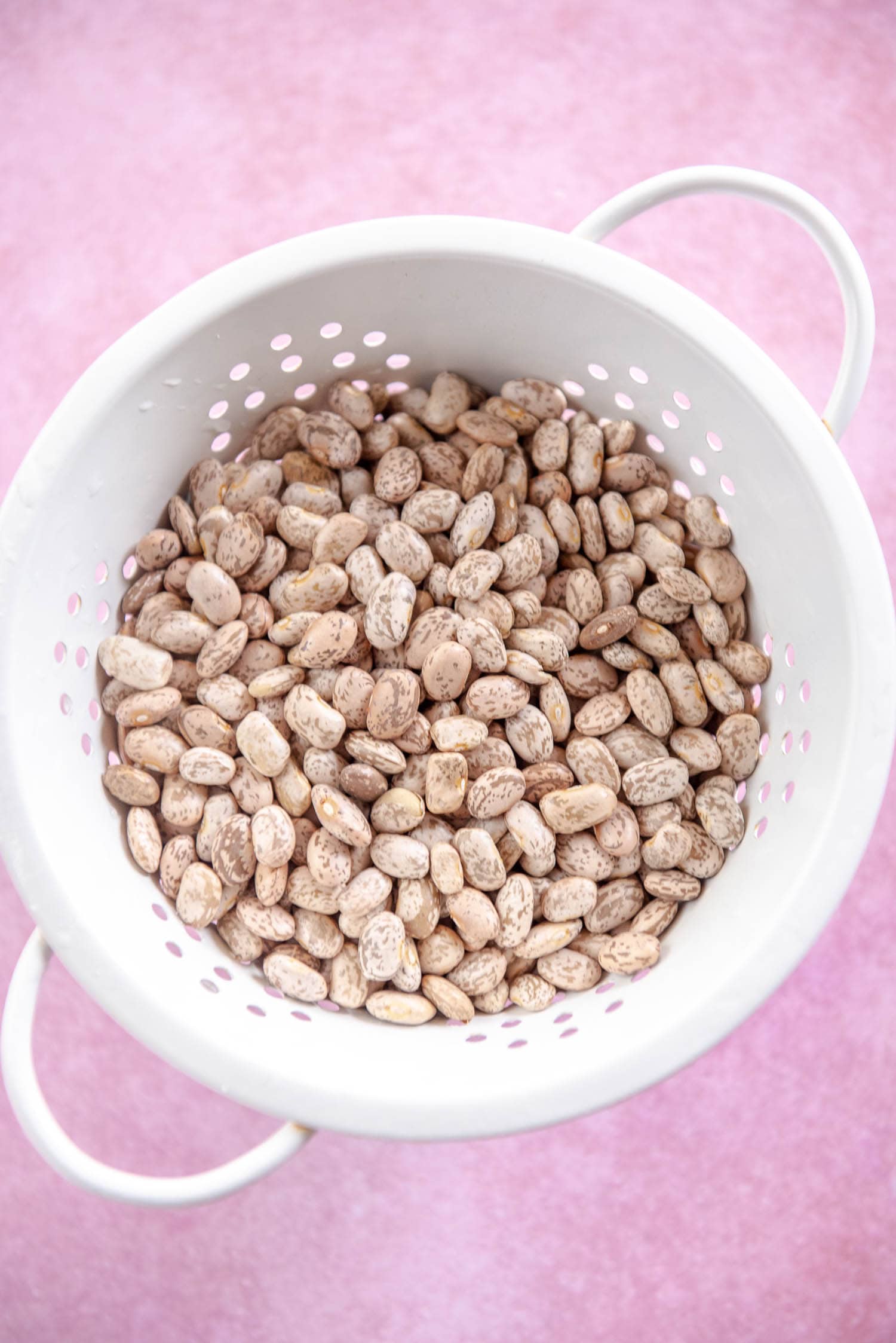 dried pinto beans in white colander