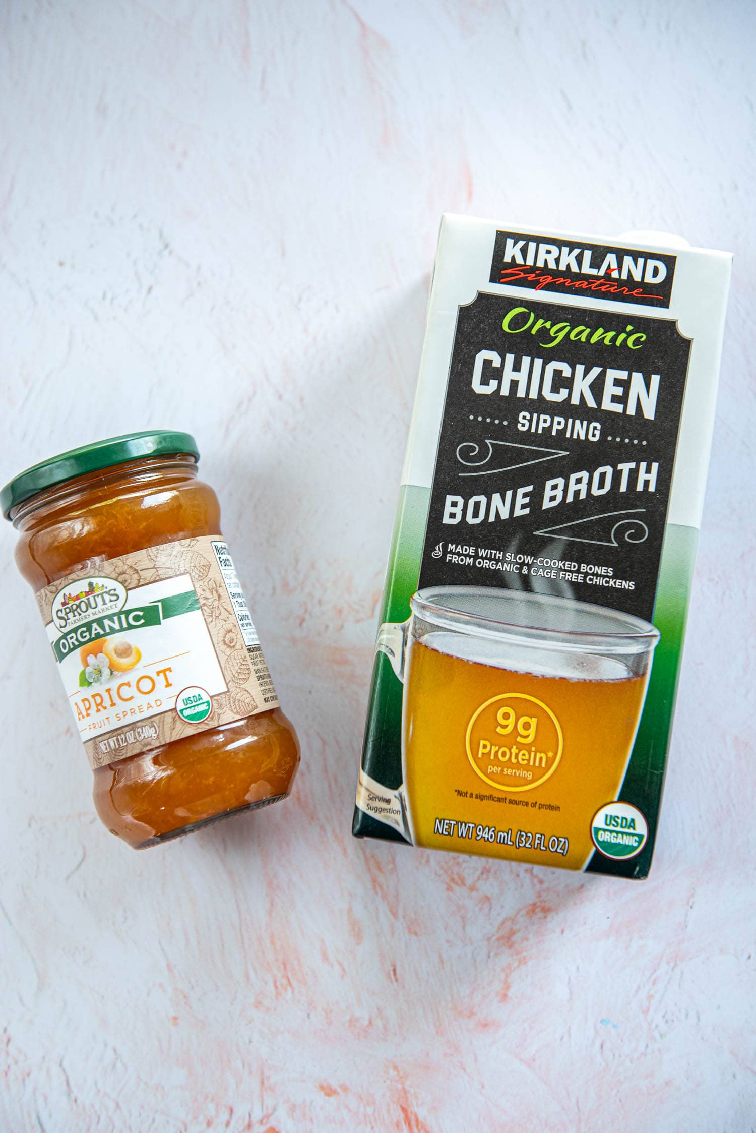 carton of chicken bone broth and jar of apricot preserves