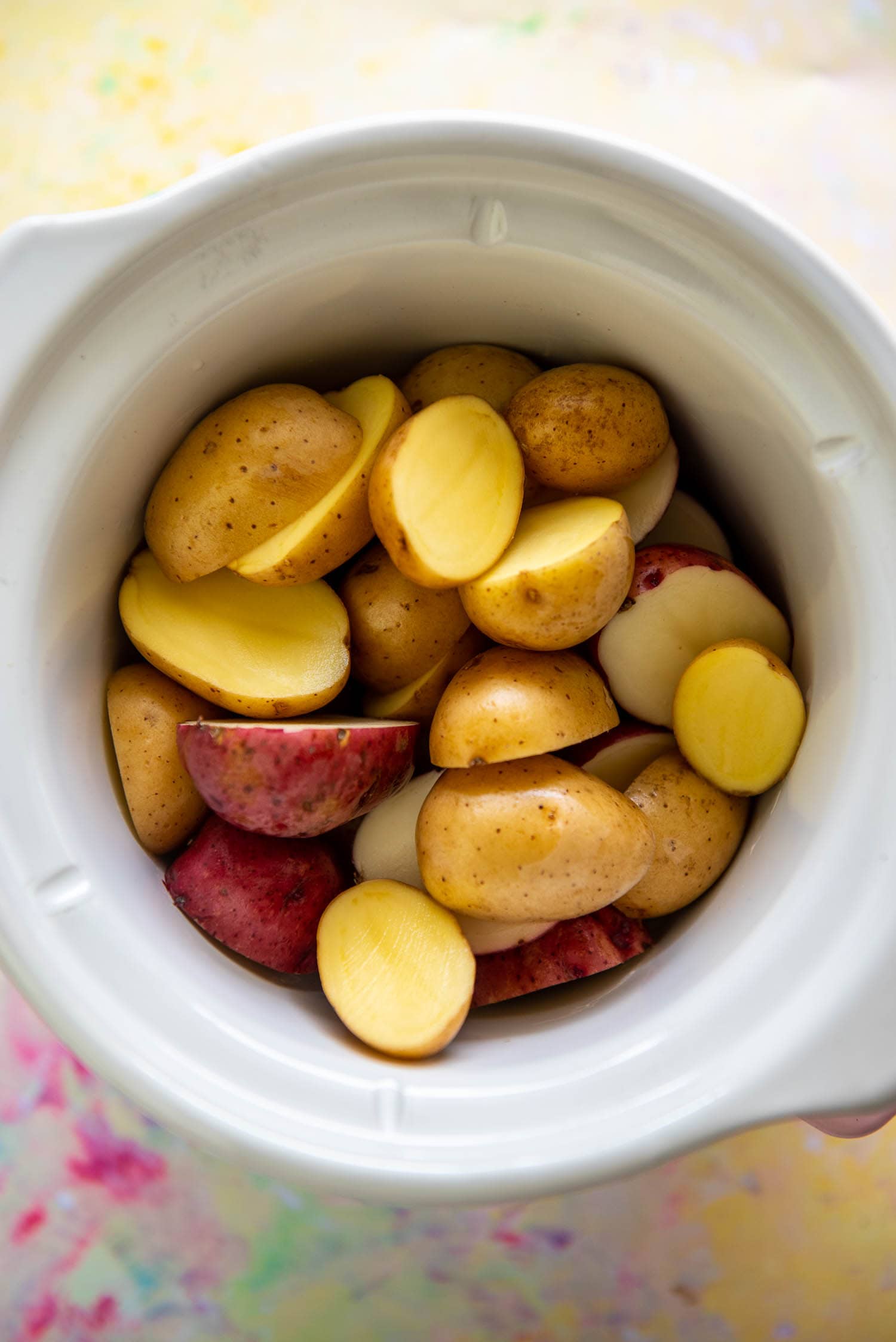 red and white baby potatoes cut in half in small round slow cooker