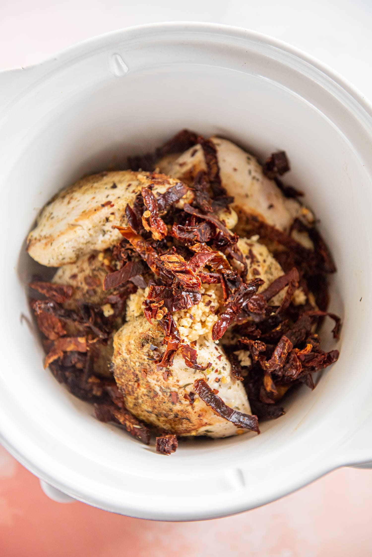 chicken and various sauces and spices inside of slow cooker