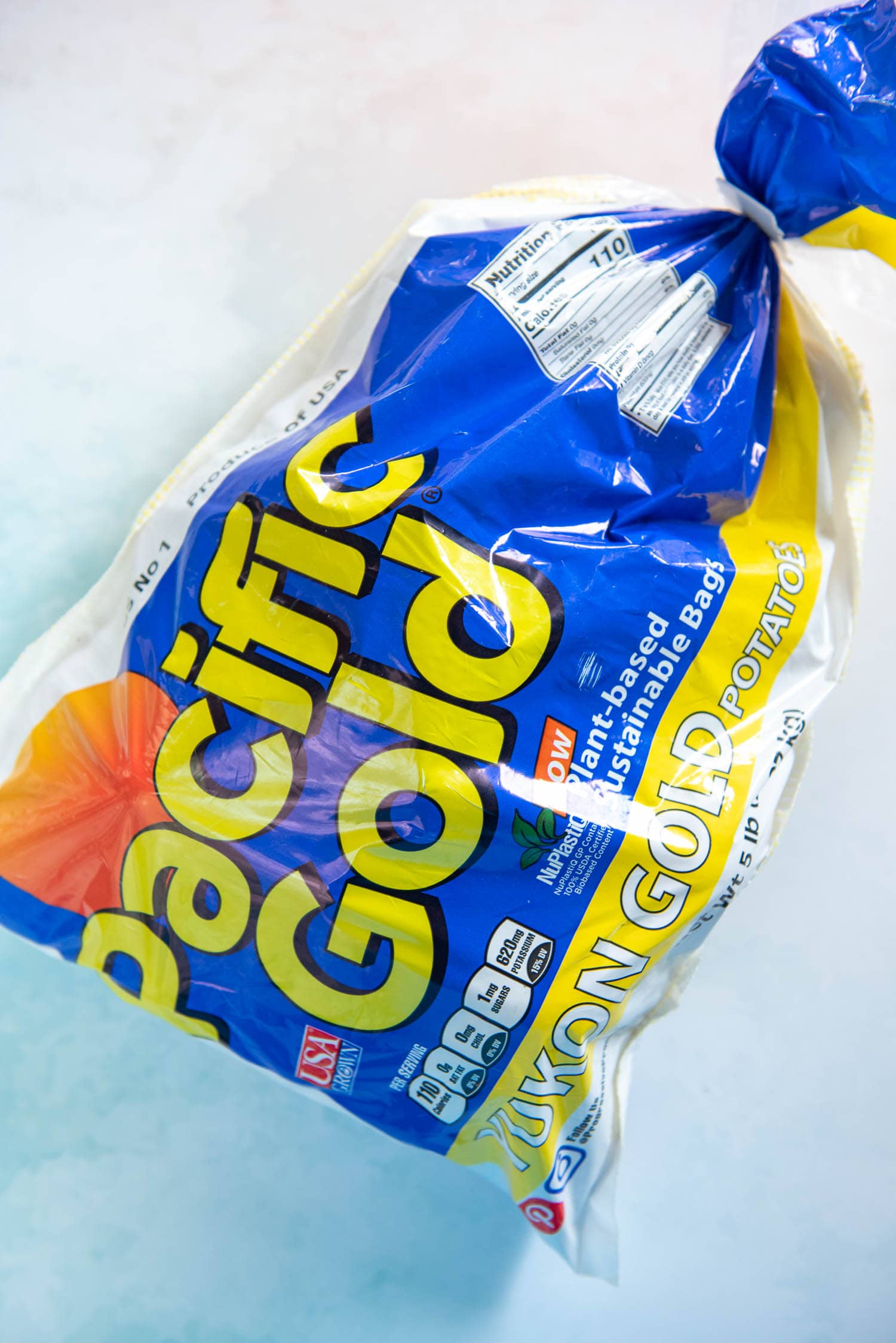 5lb bag of pacific gold yukon gold potatoes on blue surface