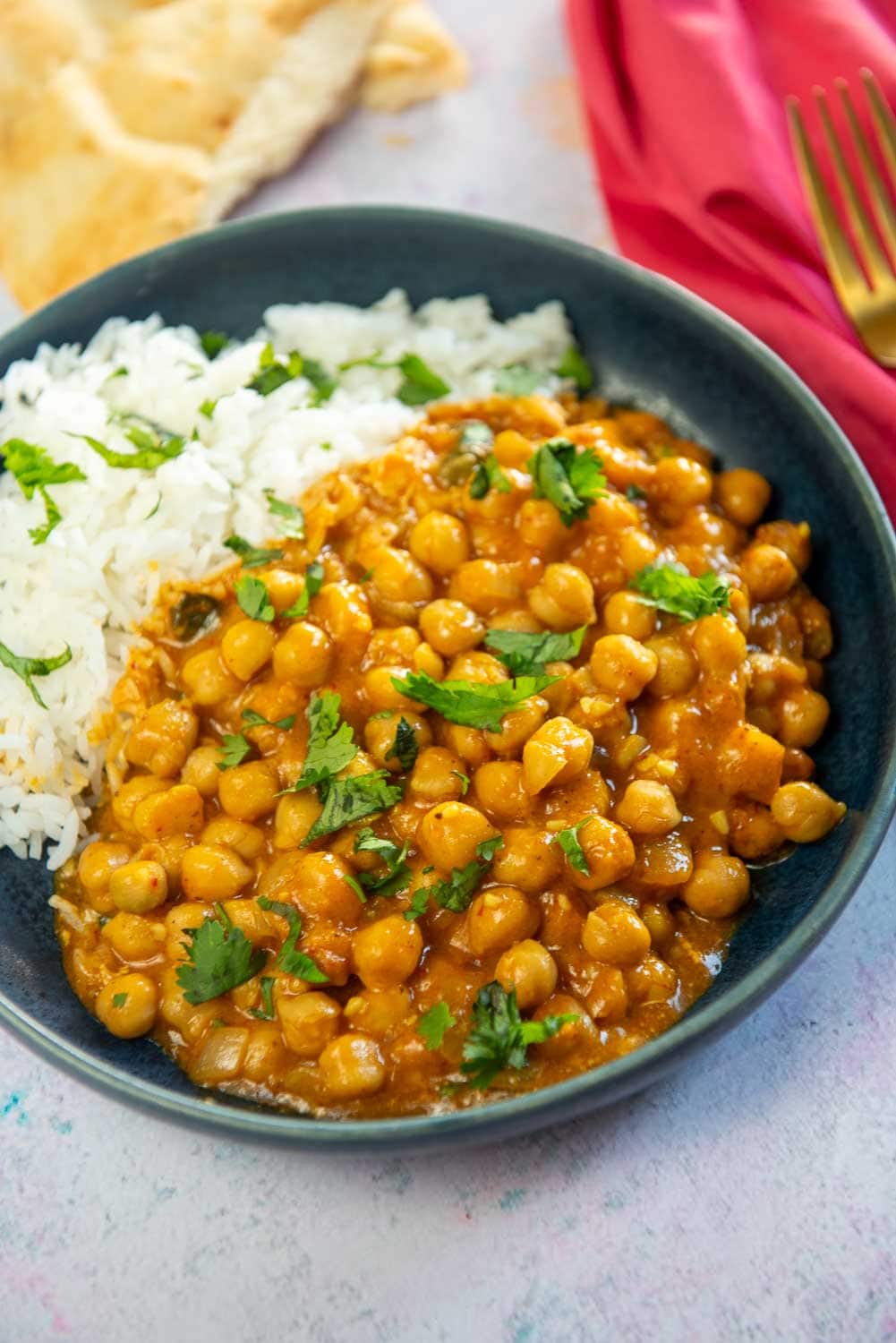 chickpeas in a curry sauce with rice on blue plate