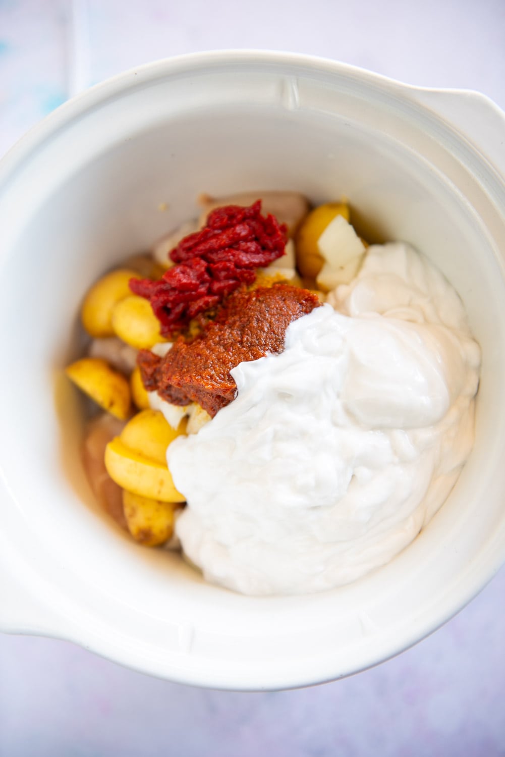 coconut milk, tomato paste, curry paste and potatoes in slow cooker