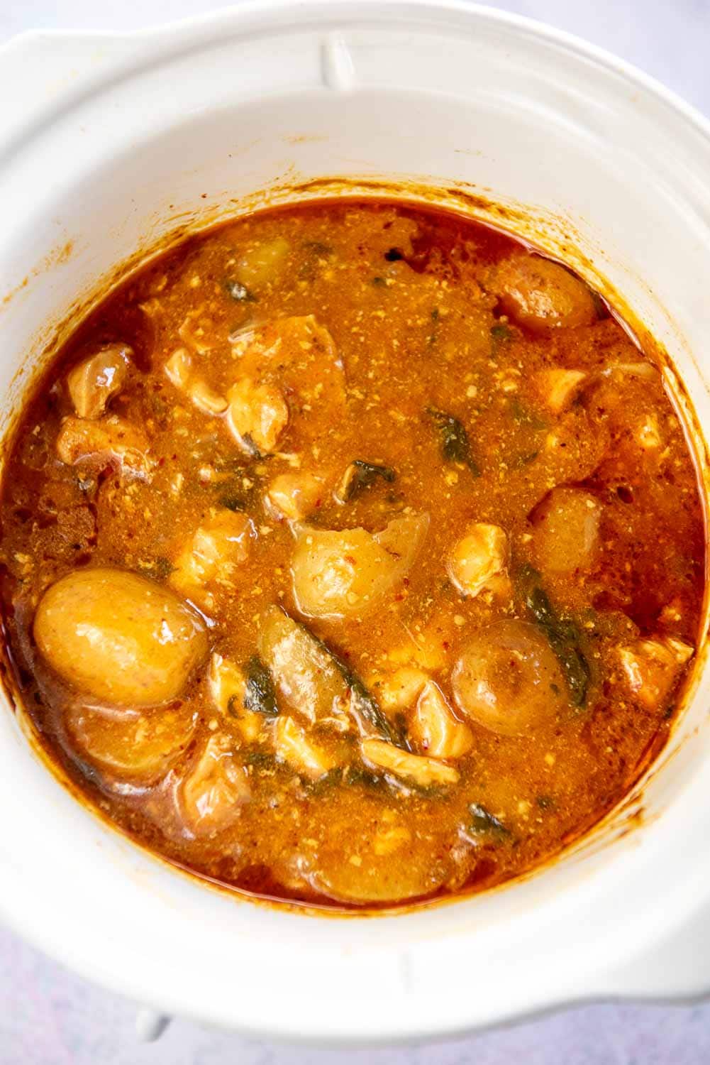 white slow cooker filled with chicken curry