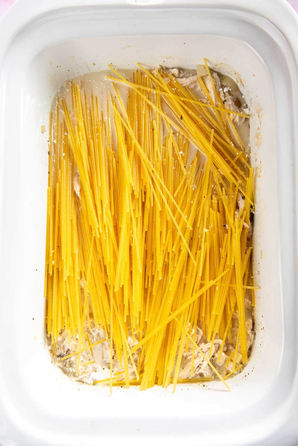 uncooked noodles on top of uncooked chicken casserole mixture