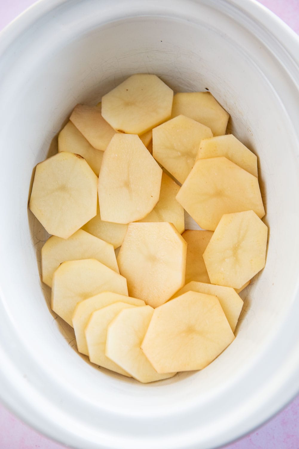 scalloped potatoes in large white slow cooker bowl