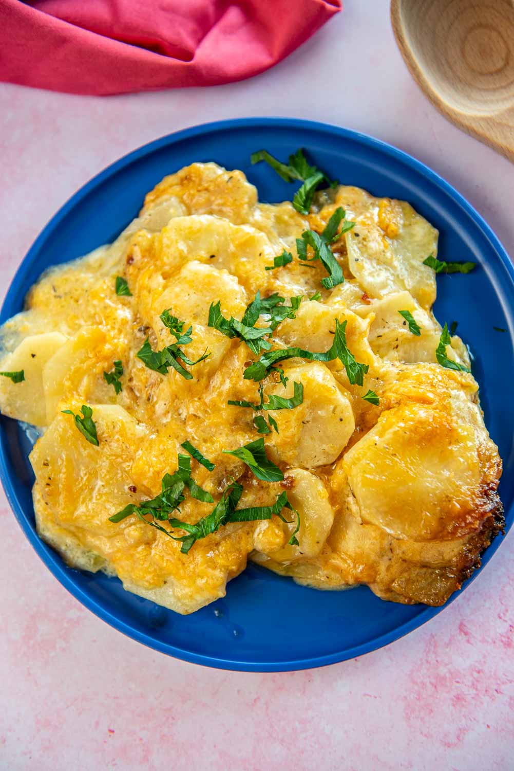 scalloped potatoes garnished served on a blue plate
