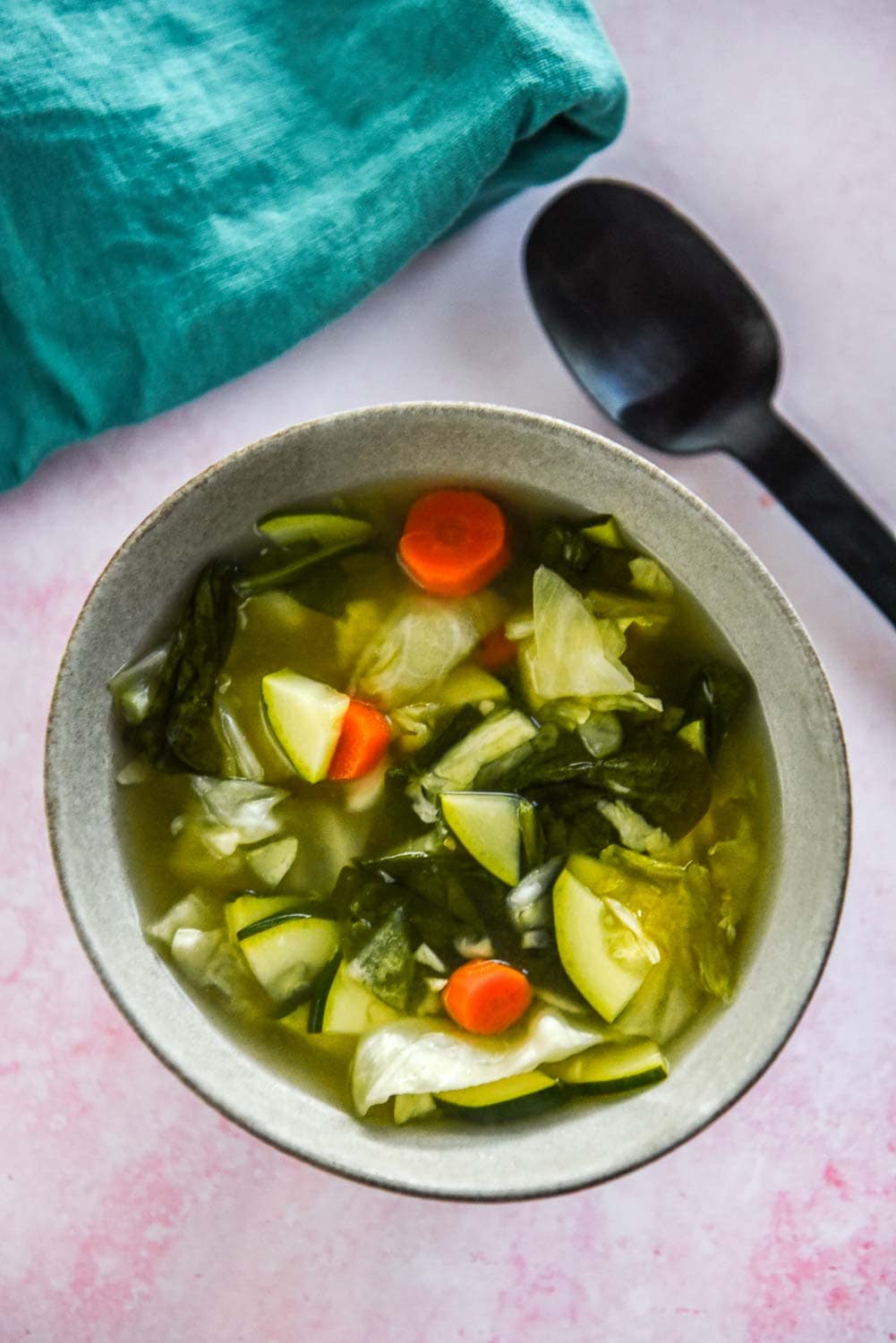 bowl of miso soup with carrots, spinach and cabbage