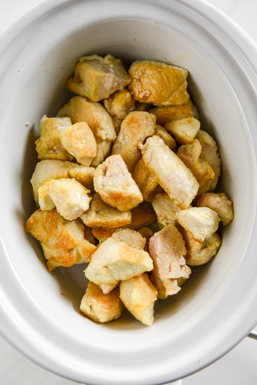 Browned chicken pieces in slow cooker