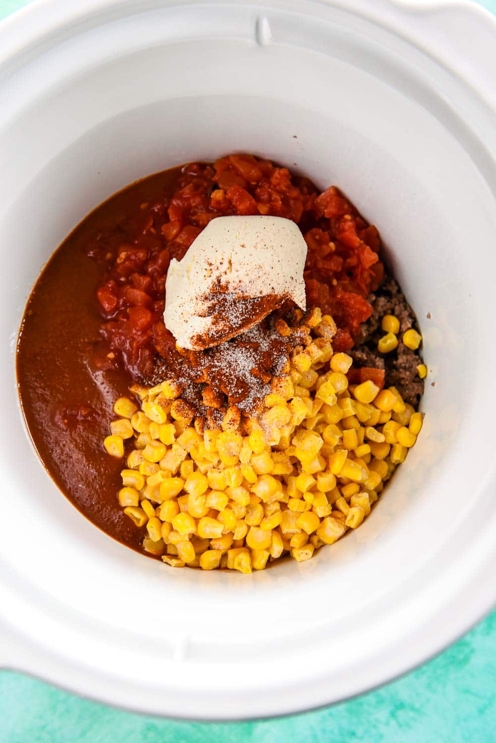 Beef, enchilada sauce, diced tomatoes, corn and cream cheese in slow cooker