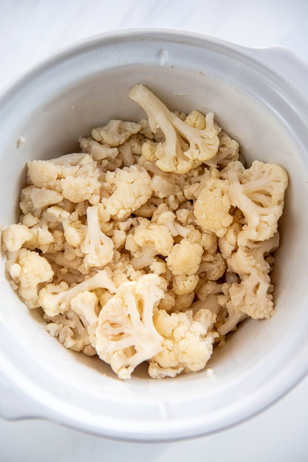slow cooker with cooked cauliflower pieces