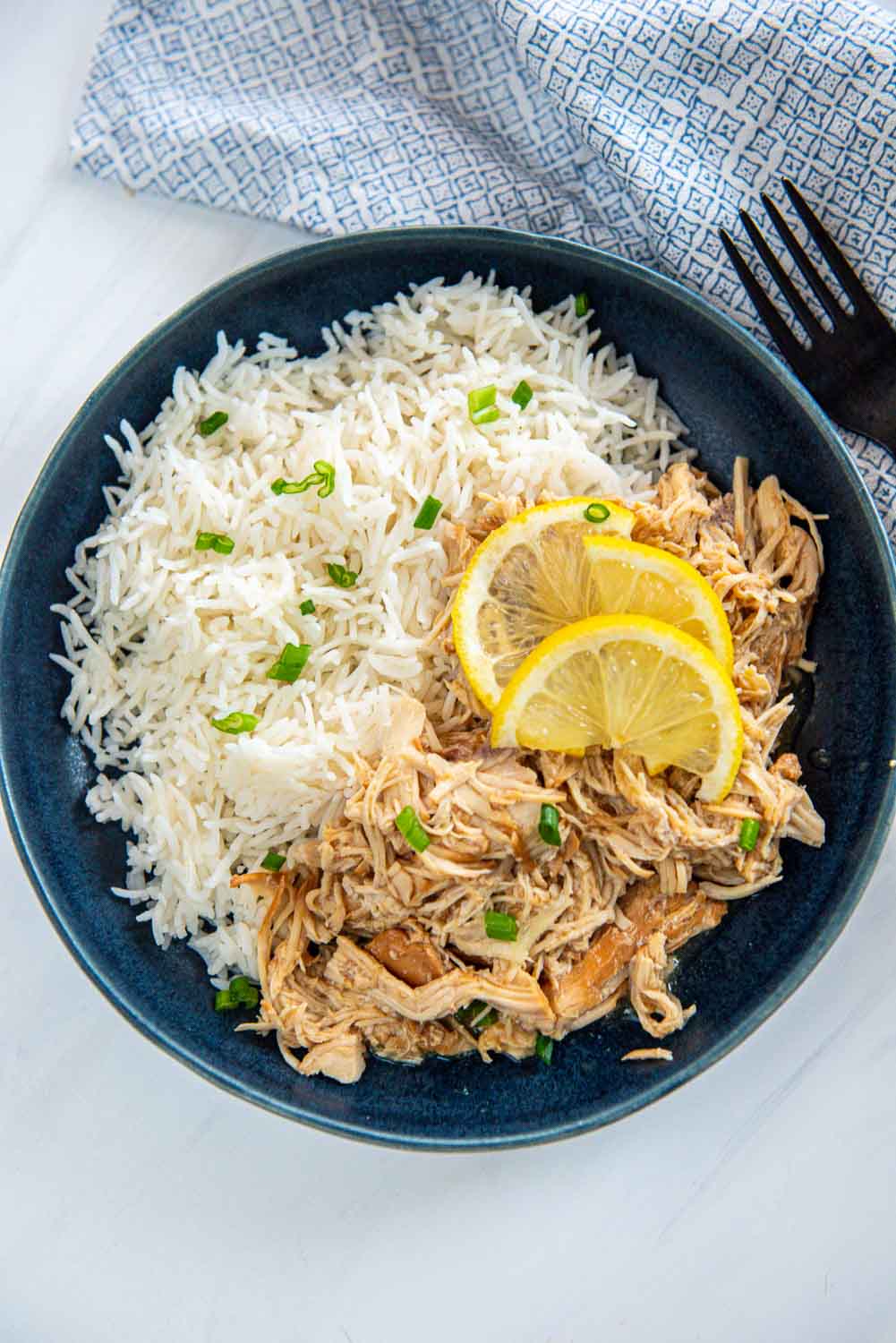 lemon chicken and rice on a blue plate