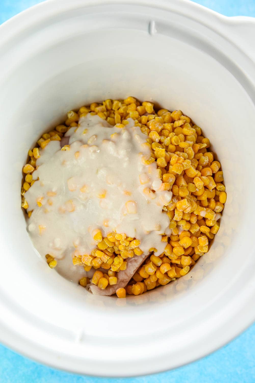 slow cooker with corn topped with flour slurry