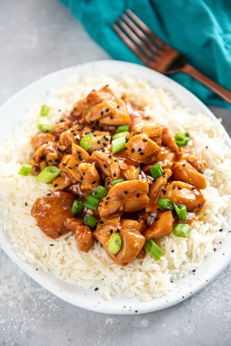Cooked Hawaiian chicken on a bed of rice garnished with green onions and black pepper