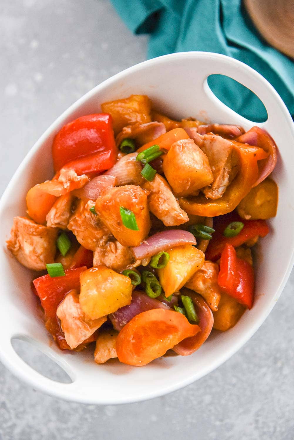 chicken with pineapple, peppers and onions in white bowl