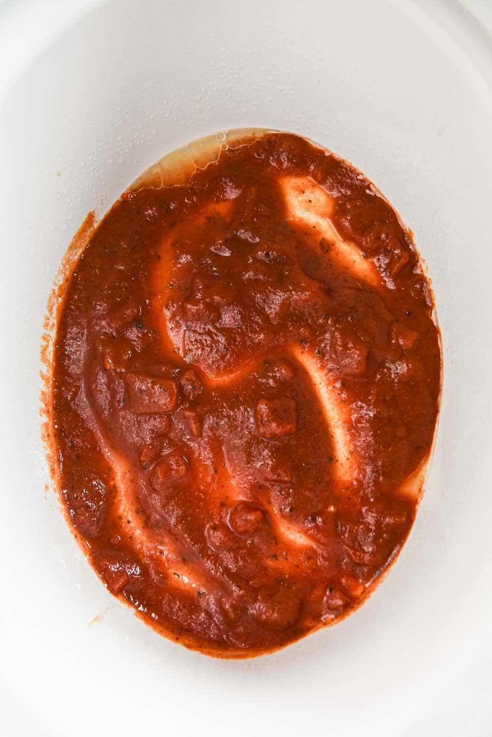 pasta sauce in bottom of slow cooker