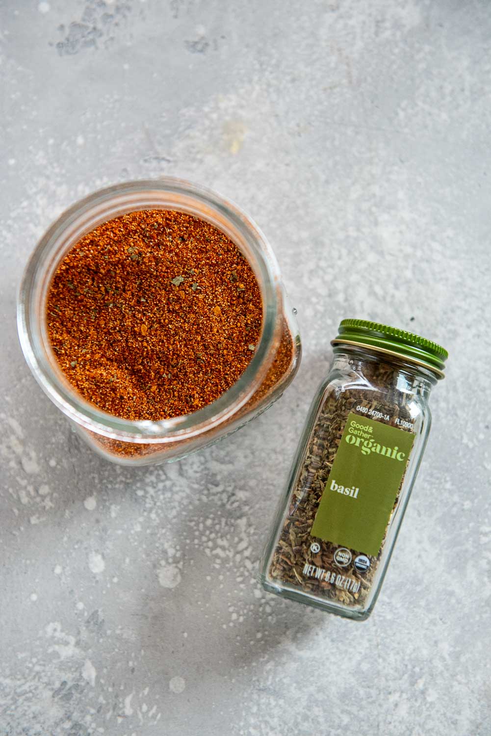 bottle of basil and small cup of seasonings