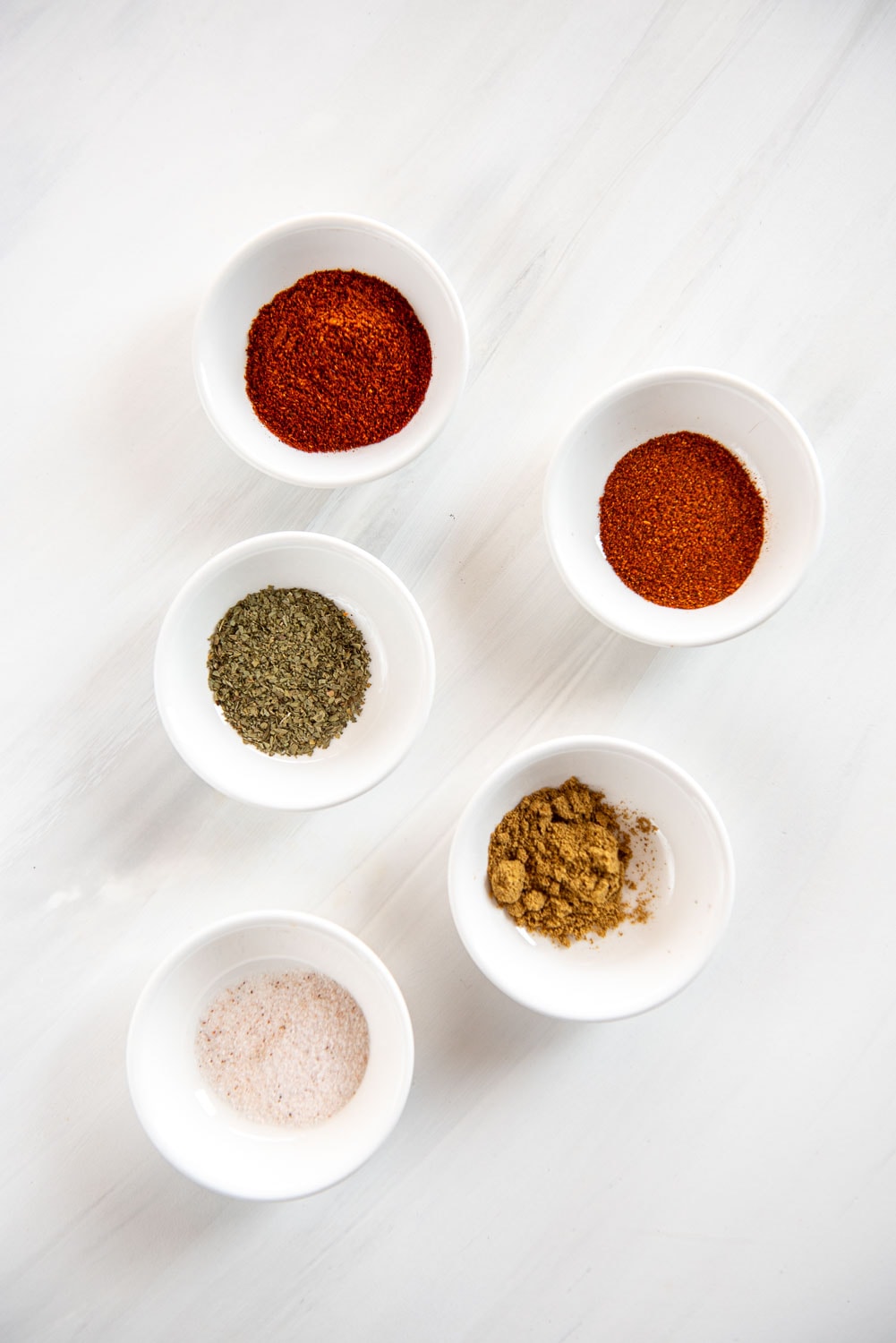 5 small dishes all containing different spices and seasonings