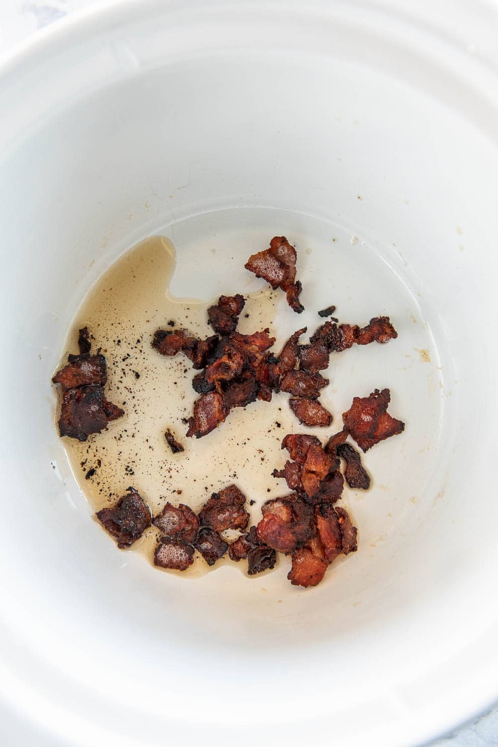 Bacon pieces cooking in the slow cooker