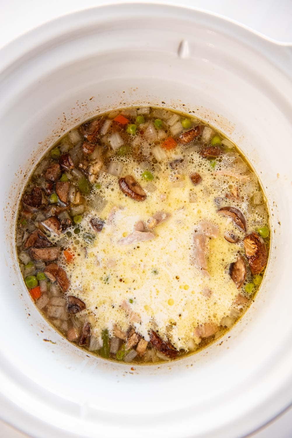 Mix of chicken, vegetables, broth, and flour mixture in slow cooker cooking