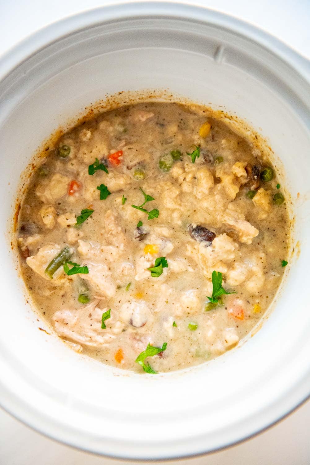 Thickened mix of chicken, vegetables, broth, and flour mixture in slow cooker