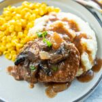 Slow Cooker Cube Steak served on plate with mashed potatoes, gravy, and corn