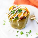Slow Cooker Stuffed Peppers drizzled with white cream and garnished