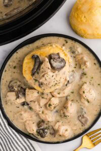 biscuit in Slow Cooker Chicken and Gravy served on plate next to fork