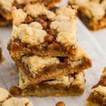 3 stacked cookie bars with caramel next to other individual pieces