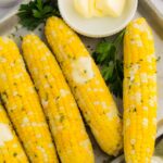 Cooked ears of corn of butter and garnishing