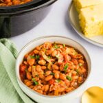 Slow Cooker Charro Beans served in bowl next to corn bread and slow cooker