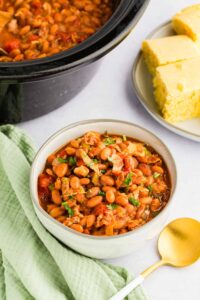 Slow Cooker Charro Beans served in bowl next to corn bread and slow cooker