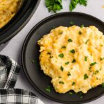 Slow Cooker Hashbrown Casserole served and garnished next to the slow slow cooker with meal inside