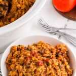 bowl of enchilada pasta next to fresh tomatoes