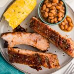Slow Cooker Baby Back Ribs served on plate with corn on the cob and bbq beans