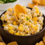 Close up of Slow Cooker Jalapeno Corn Dip in small bowl served on dish with chips