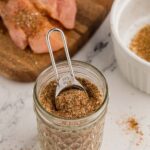 Homemade Chicken Taco Seasoning in mason jar with 5 ml tsp inside scooping the mixture